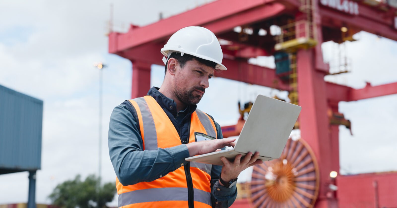 Homme d'affaires concentré sur un ordinateur, travaillant sur une rédaction technique précise et sobre pour ingénieurs